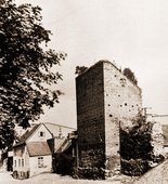 Ruiny murów średniowiecznych z basztą i zabudowanie mieszkalne. Początek XX w.
